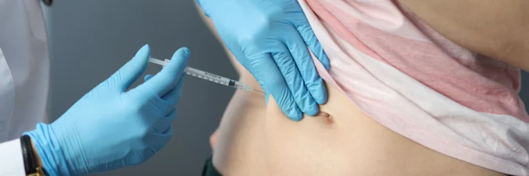 Photo doctor in rubber gloves making injection into patients skin fold close-up. diabetes treatment concept