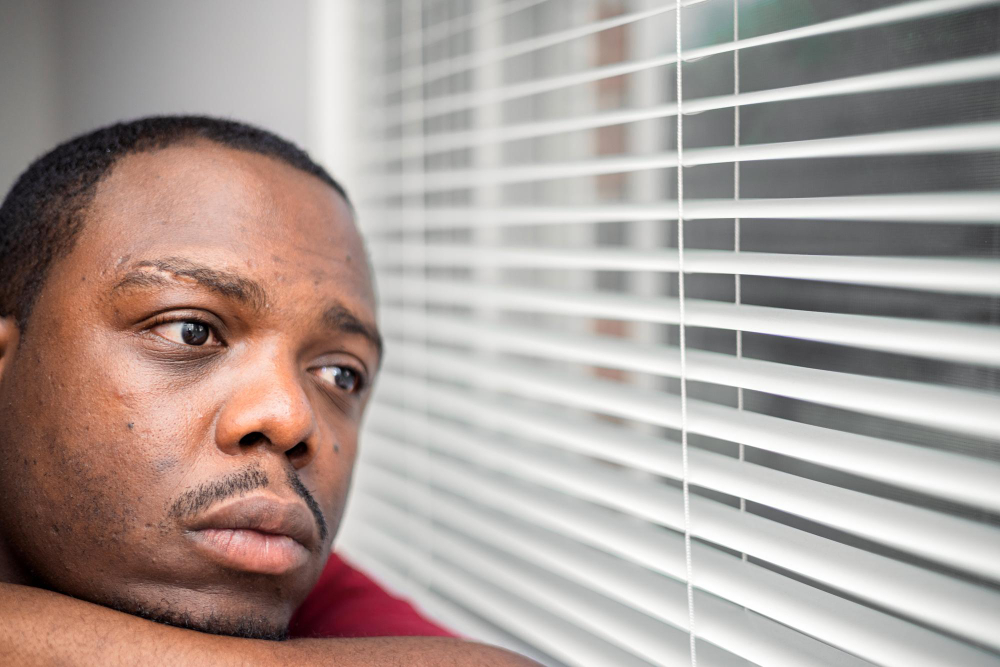 young-depressed-anxious-african-american-man-bedroom-home-sitting