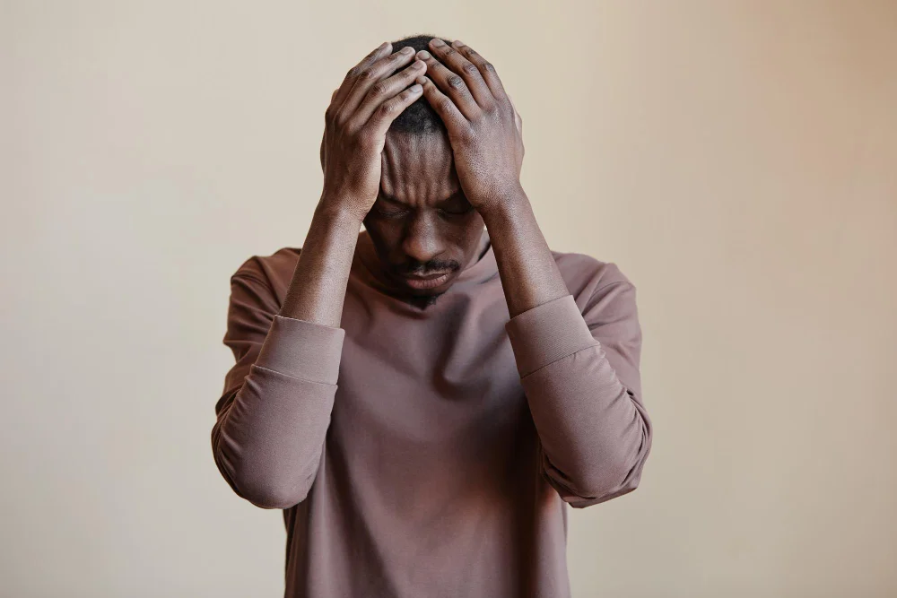 Black man holding head in hands felling Depression