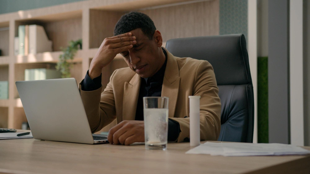 African American overworked businessman throw fizzy pill in glass of water apply drug supplement