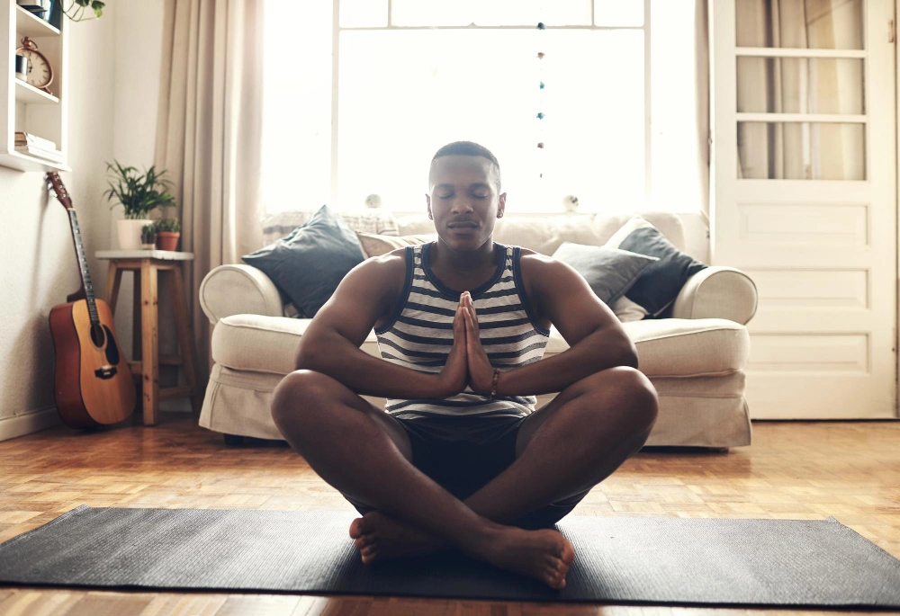 A little focus can drive so much positivity into your life Shot of a sporty young man meditating at home