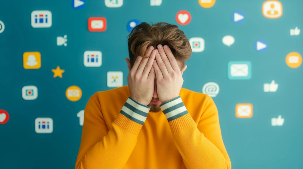 Closeup of a person holding their head in frustration surrounded by various social media icons