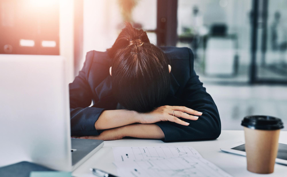 Laptop sleep or tired woman in office with burnout documents or tax audit