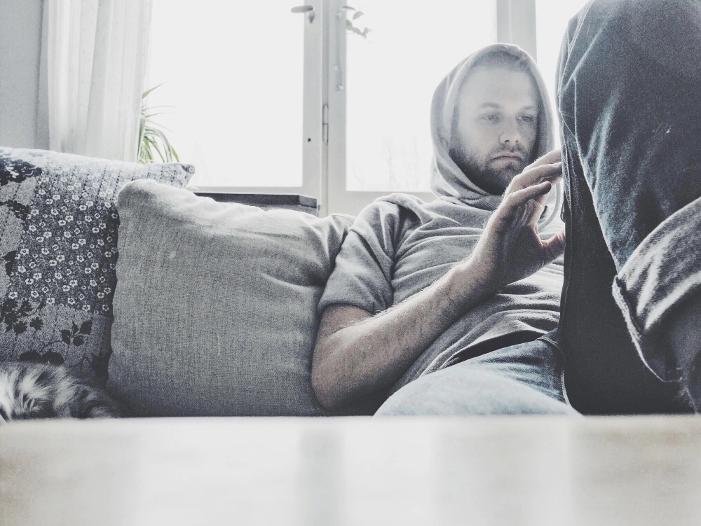 Close-up of young man using mobile phone at home