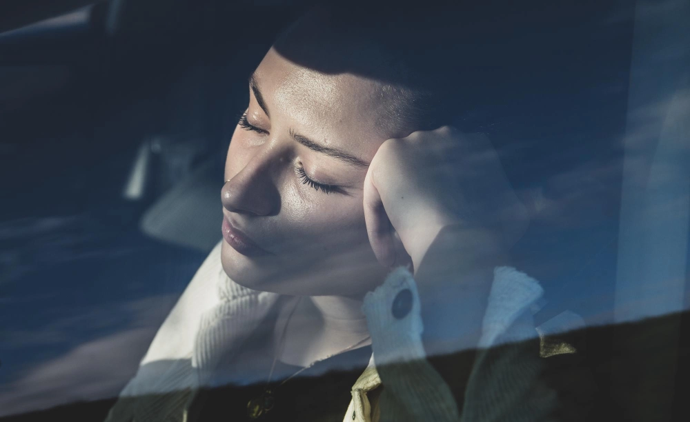 Close-up of young woman sleeping in car